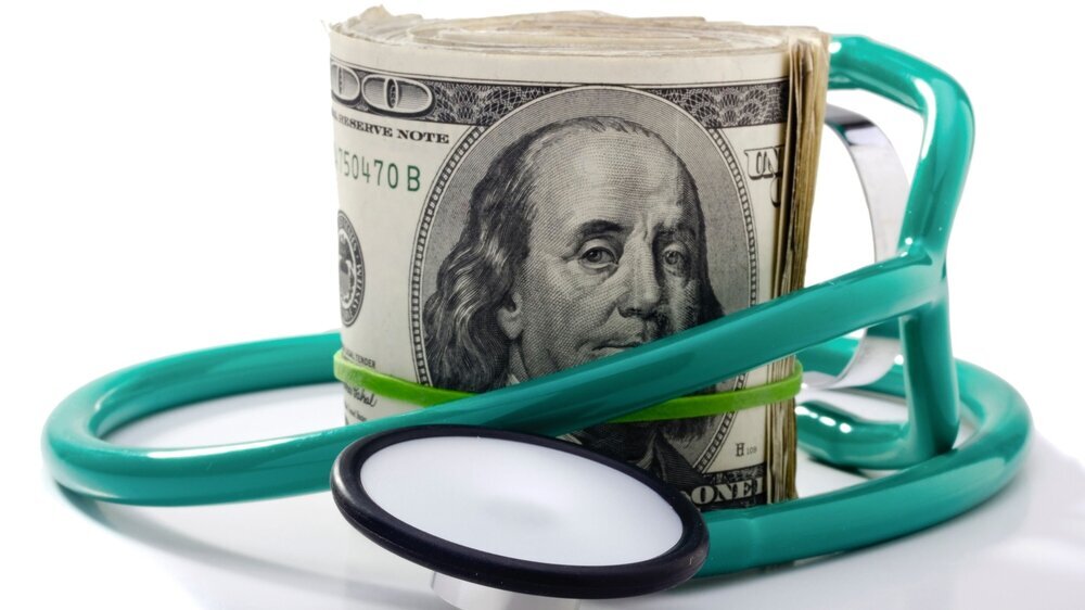 Stethoscope and Money Rolle mit Dollarscheinen und Stethoskop