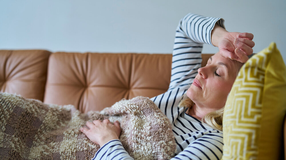 Economically Inactive Woman Suffering With Long Term Illness On Sofa At Home Post COVID, krank