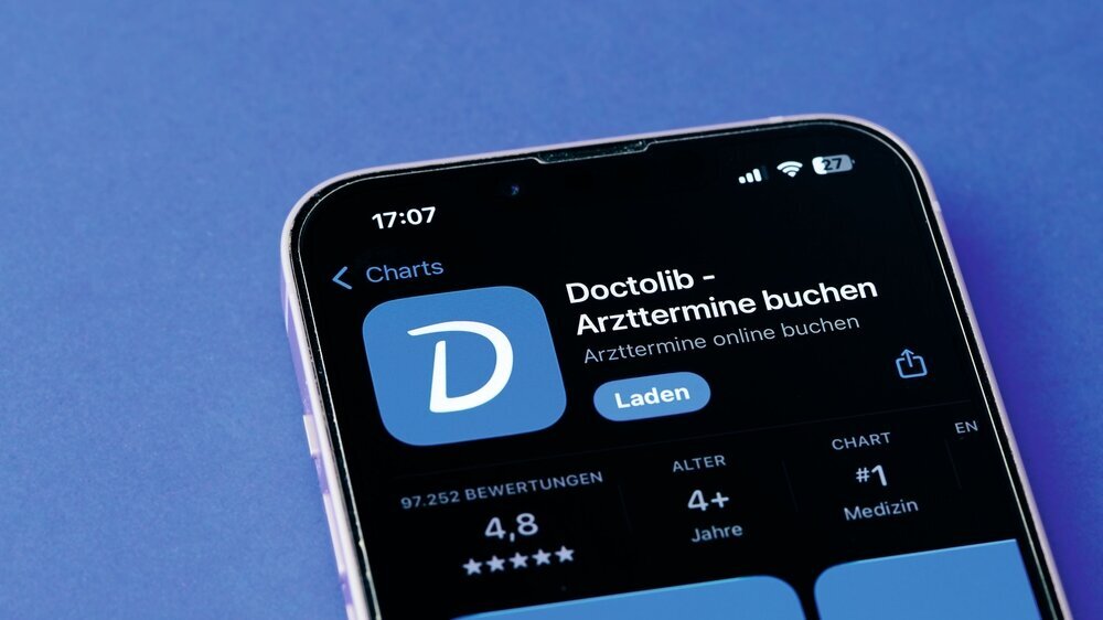 Symbol der Doctolib-App auf einem Smartphone-Bildschirm auf blauem Hintergrund Symbol der Doctolib-App auf einem Smartphone-Bildschirm auf blauem Hintergrund