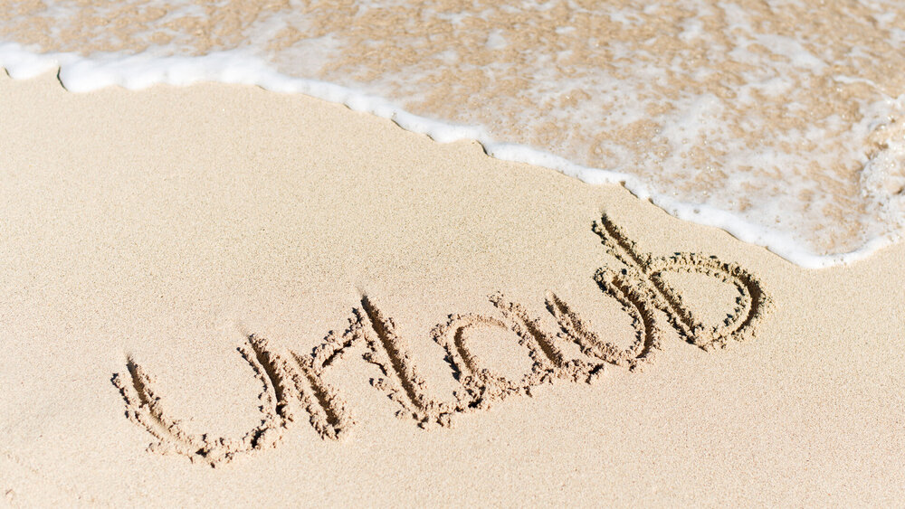 Urlaub als Schriftzug im Sand am Strand.