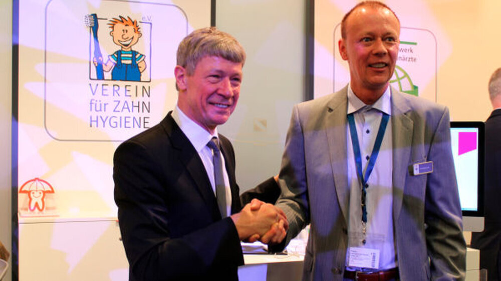 Zum Geburtstag alles Gute! Prof. Dietmar Oesterreich, Vizepräsident der Bundeszahnärztekammer, gratuliert Andreas Lehr - stellvertretend! Denn nicht der Geschäftsführer feiert heute - wohl aber der Verein für Zahnhygiene.