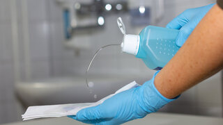 Wischdesinfektion der Oberflächen mit Handtüchern und Handschuhen.