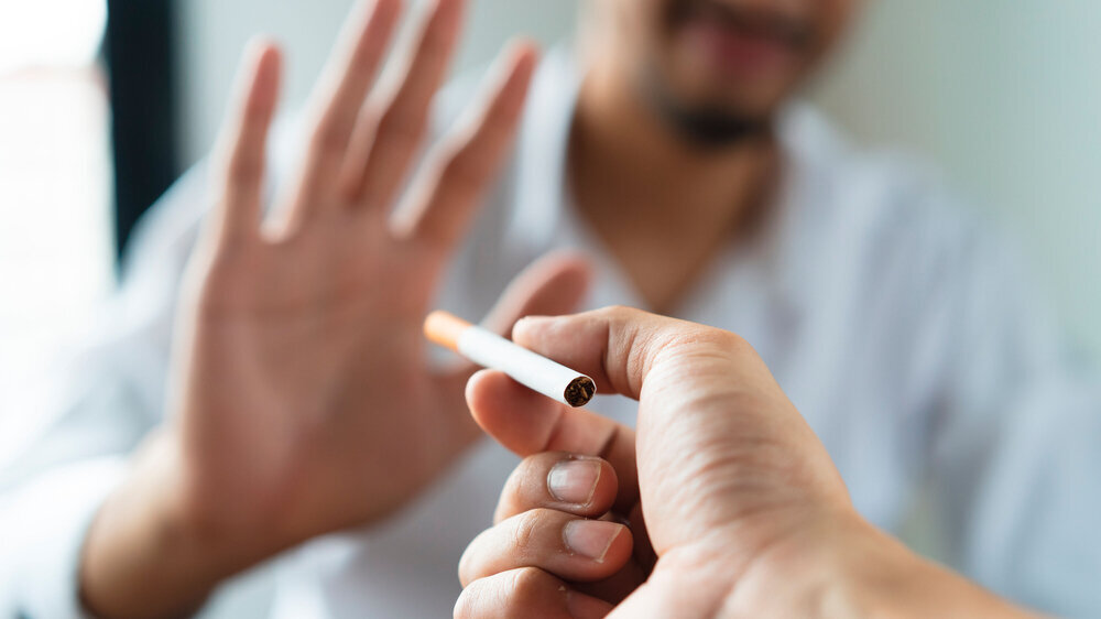 Zigarette? Nein, danke. Mann erhebt ablehnend seine Hand bei einer angebotenen Zigarette.