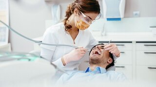 Female dentist working on patient's teeth.