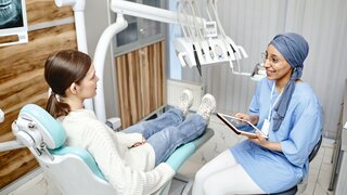 ZFA mit Kopftuch im Gespräch mit einer Patientin