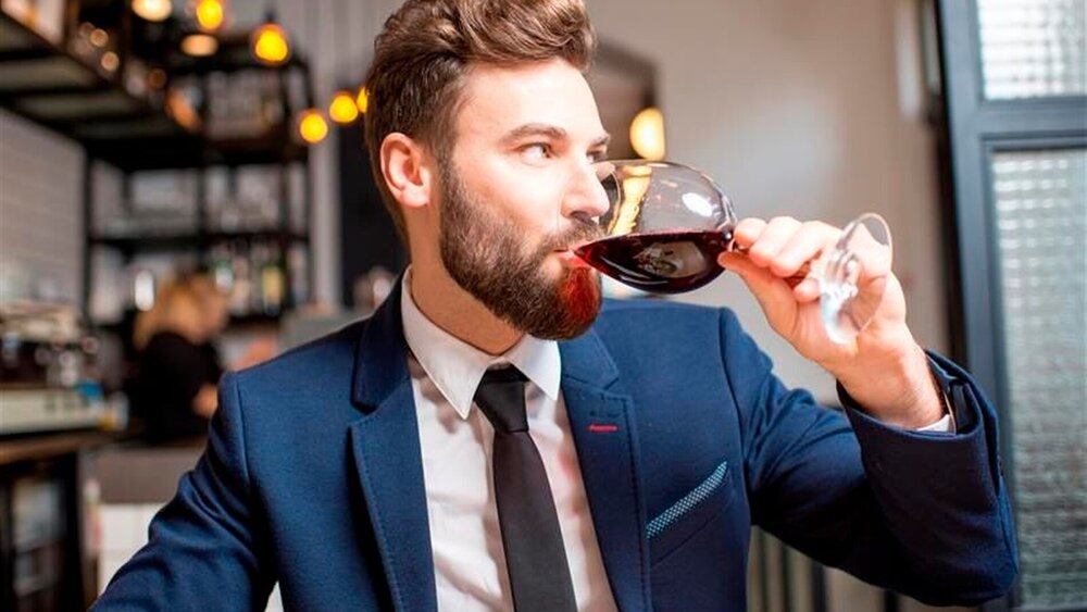 Mann trinkt Rotwein in modernem Restaurant