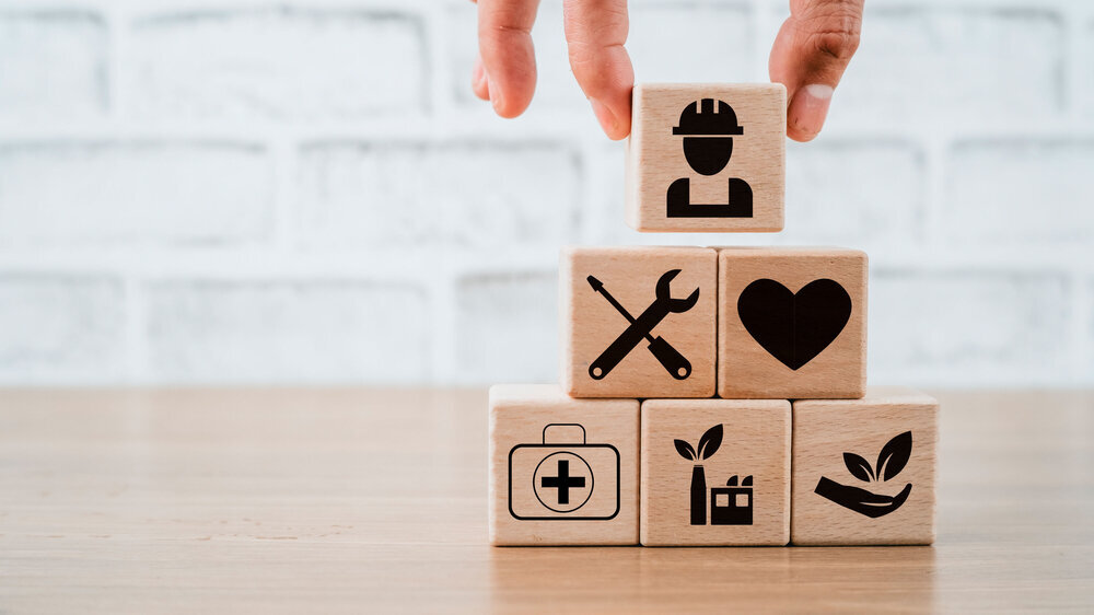 Health safety environment HSE education industry Concept, Man hand holding wooden cube block with Health safety environment icon with copy space. Symbolbild Umwelt- und Gesundheitsschutz