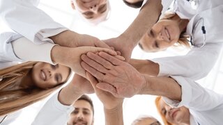 close up. group of different doctors putting their hands together . concept of unity.