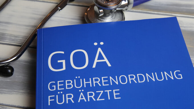 Viersen, Germany - May 9. 2021: Closeup of isolated book with stethoscope about german doctors scale of fees (Gebuhrenordnung, goa) for private insurance (focus on center of upper lettering) GOÄ