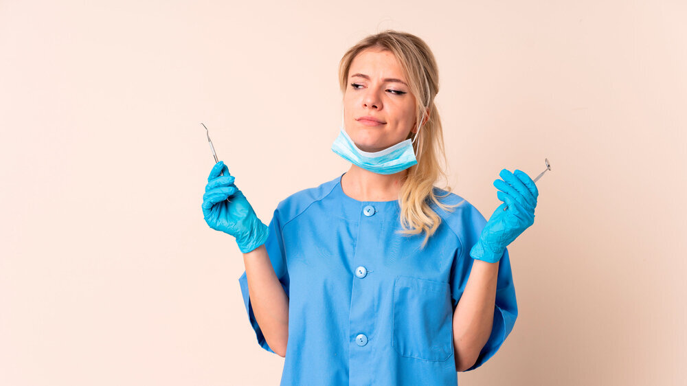 Dentist woman holding tools over isolated background ZFA