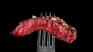 Beef meat rare on fork black background