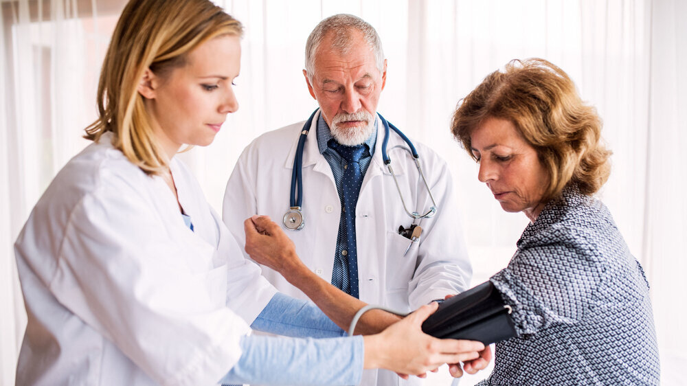 Arzt mit Patientin und MFA