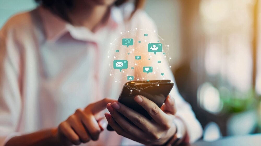 Frau hält Smartphone in der Hand und bedient Social Media.