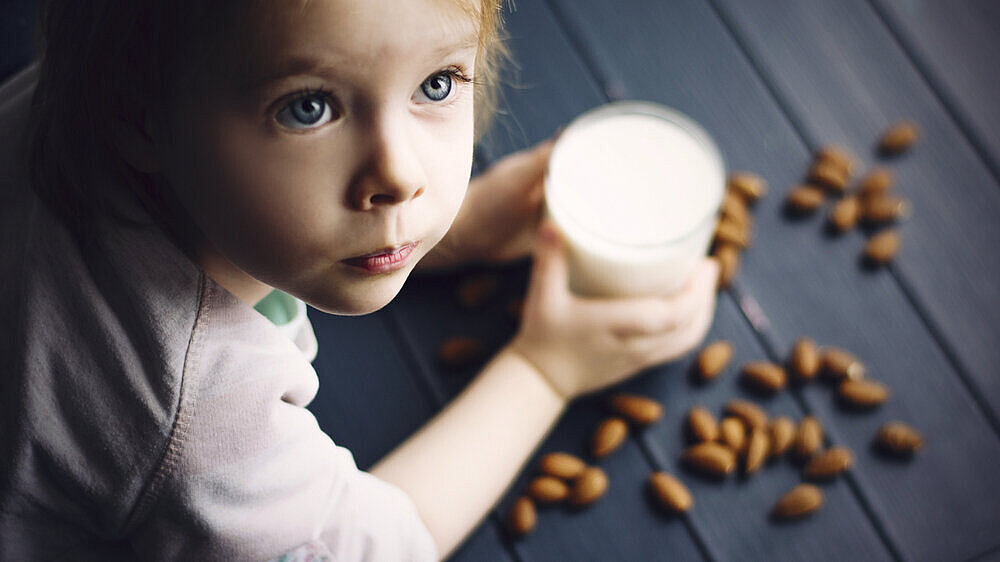 Kleines Mädchen mit Milch und Mandeln Kleines Mädchen mit Milch und Mandeln