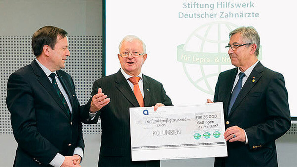 Zu seinem Jubiläum initiierte das HDZ mit dem Deutschen Roten Kreuz (DRK) ein Projekt zum Bau einer Gesundheitsstation in Kolumbien. Der symbolische Scheck über 35.000 Euro wurde von Dr. Klaus Sürmann (HDZ, l.) und Dr. Klaus Winter (HDZ, r.) an den DRK Zu seinem Jubiläum initiierte das HDZ mit dem Deutschen Roten Kreuz (DRK) ein Projekt zum Bau einer Gesundheitsstation in Kolumbien. Der symbolische Scheck über 35.000 Euro wurde von Dr. Klaus Sürmann (HDZ, l.) und Dr. Klaus Winter (HDZ, r.) an den DRK-Präsidenten Dr. Rudolf Seiters, Minister a.D., übergeben.