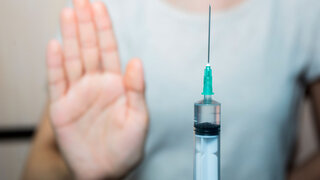 Gegen die einrichtigungsbezogene Impfpflicht: Erhobene Hand signalisiert nein zur Impfung.