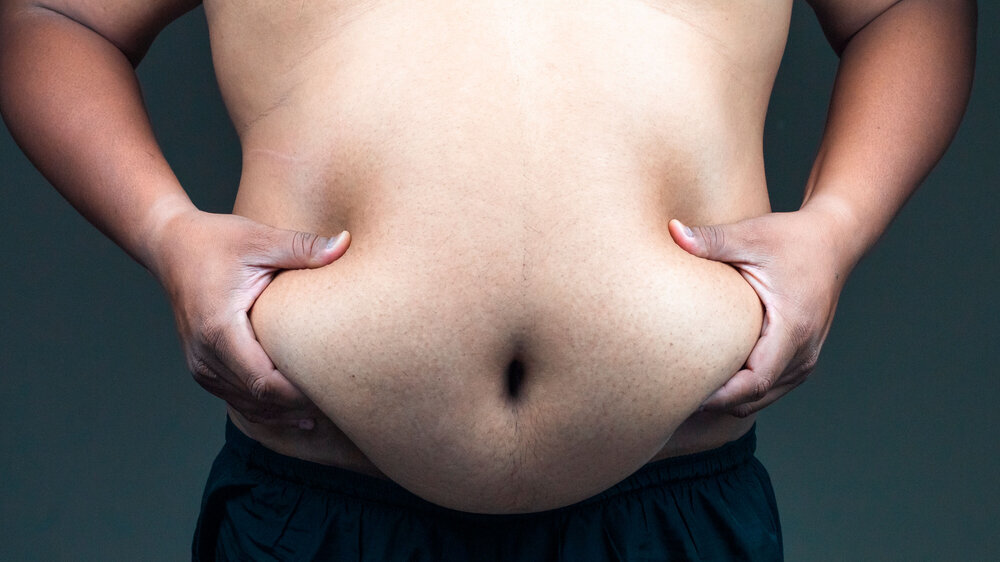 Fettleibiger Mann hält nackten Bauch. Fettleibiger Mann hält nackten Bauch.