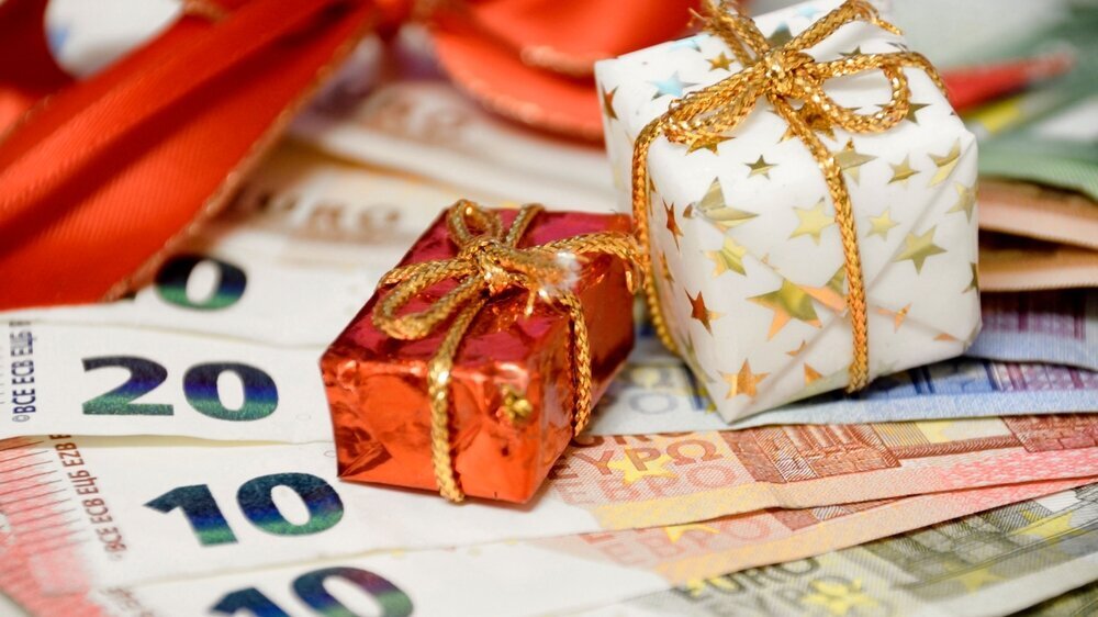 Weihnachtsgeschenke und Geldscheine.