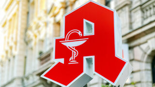 Logo Apotheke vor Häuserfassade