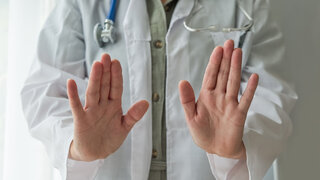 Arzt wehrt mit Stopgeste einen Angriff ab