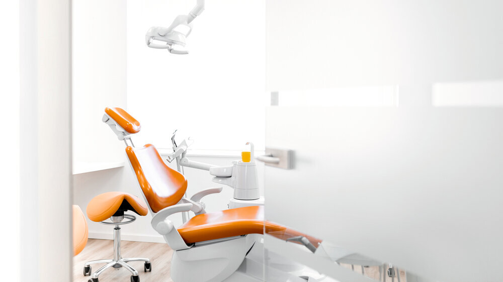 Behandlungsraum beim Zahnarzt mit orange farbenen Stühlen