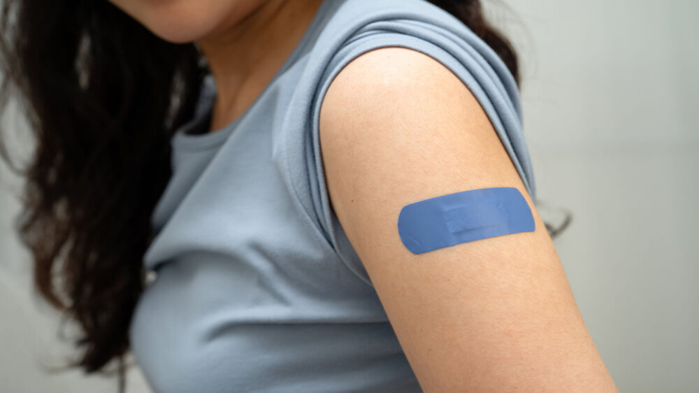 HPV, Human papillomavirus, Asian young woman receiving vaccine with blue bandage.