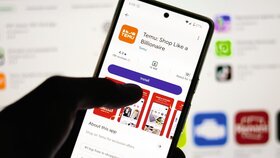 Man installing Temu shopping app on his smartphone