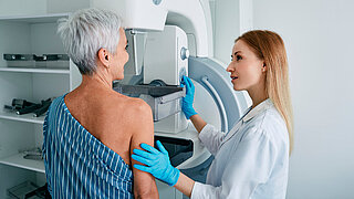 Senior woman having mammography scan at hospital with medical technician. Mammography procedure, breast cancer prevention