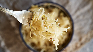 Homemade fermented cabbage or sauerkraut on a fork, top view