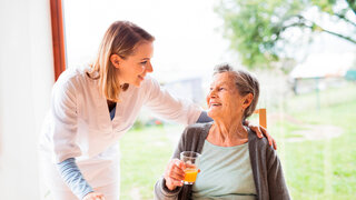 Pflegerin mit Seniorin