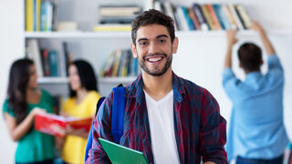 Lachender Student in der Uni-Bibliothek