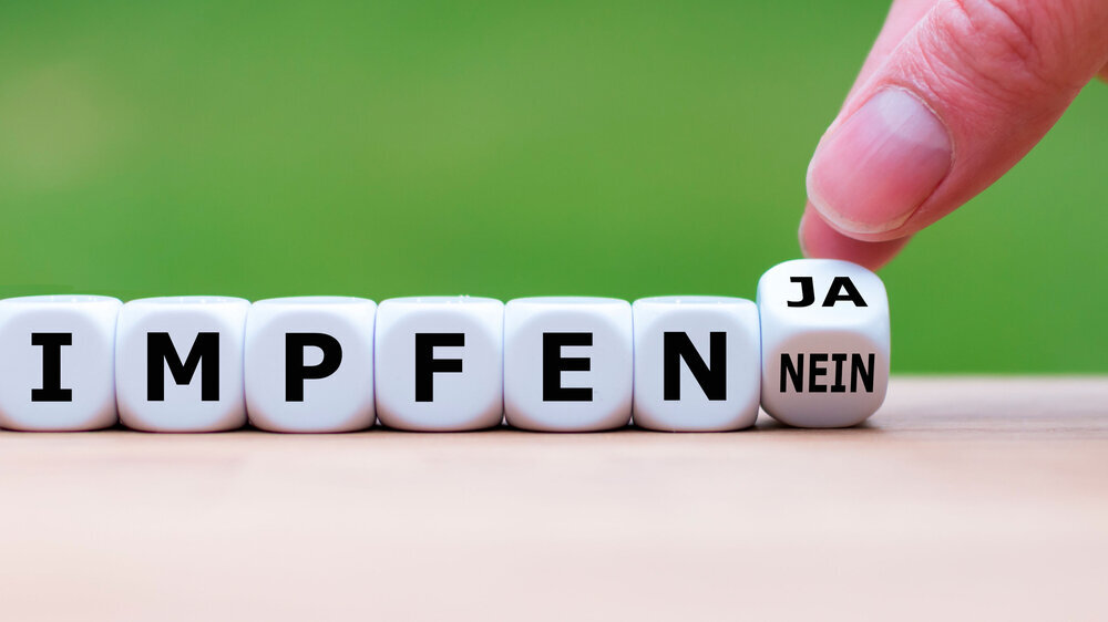 Für oder gegen eine Impfpflicht? Hand dreht einen Würfel und ändert das Wort "nein" in "ja" (oder umgekehrt). Hand dreht einen Würfel und ändert das Wort "nein" in "ja" (oder umgekehrt).