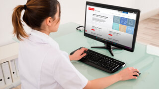 Young Female Doctor Video Conferencing With Medical Team On Digital Tablet