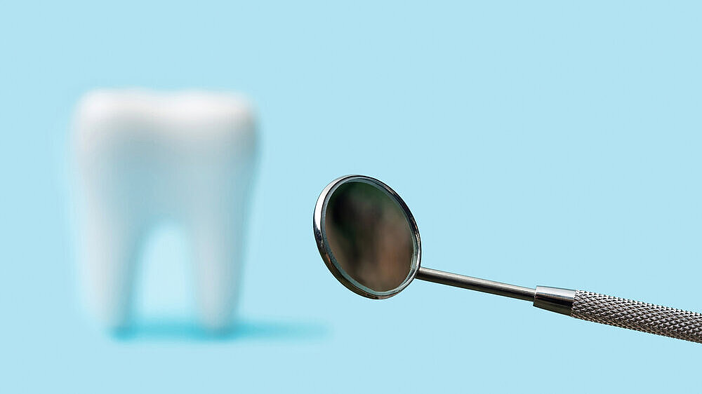 False teeth and plain mouth mirror on a blue background. False teeth and plain mouth mirror on a blue background.