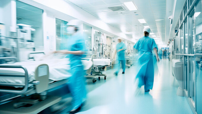 Long exposure blurred motion of medical doctors and nurses in a hospital ward wearing blue aprons, walking down a corridor - Generative AI KH