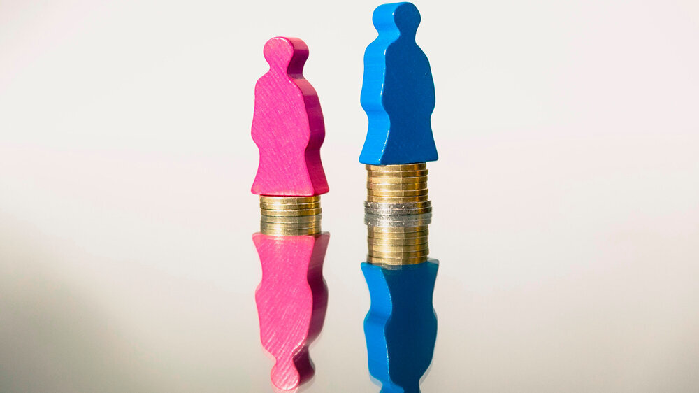 Gender pay gap mit Spielsteinen auf Münzen