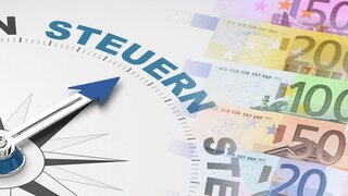 Informationen zur steuerlichen Aspekten: Ein Kompass-Pfeil zeigt auf Eurogeldscheine.