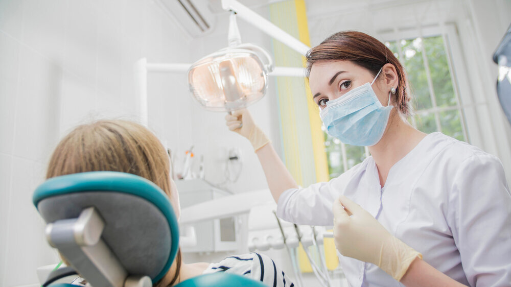 young woman doctor in a dental clinic. the dentist sits in the Cabinet beside the chair with the patient ZÄ