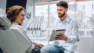 Zahnarzt im Beratungsgespräch mit Patientin