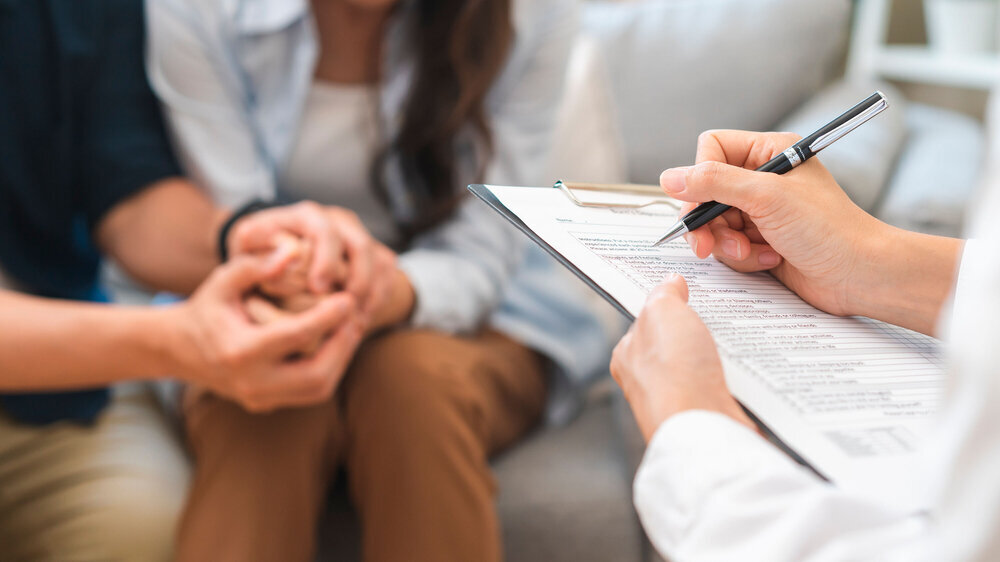 Psychology, depression asian young couple, patient consulting problem mental health with psychologist, psychiatrist at clinic together, husband encouraging by holding hand of wife, therapy health care Arztgespräch, Psychologe