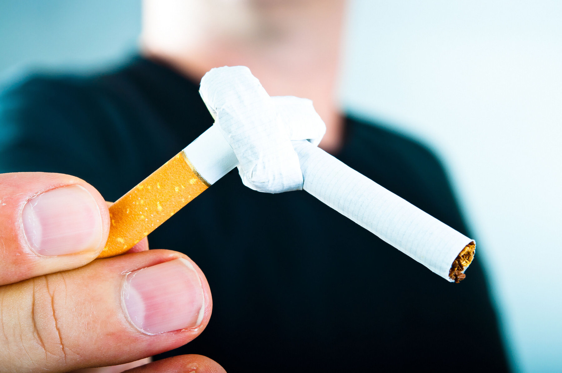 Mann hält gekotete Zigarette