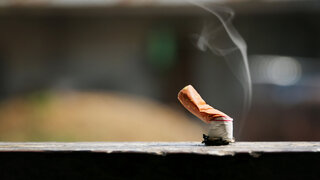 Ausgedrückte Zigarette auf dem Gehweg. Umweltverschmutzung.