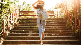 Spaziergängerin im Park bei Sonnenlicht.