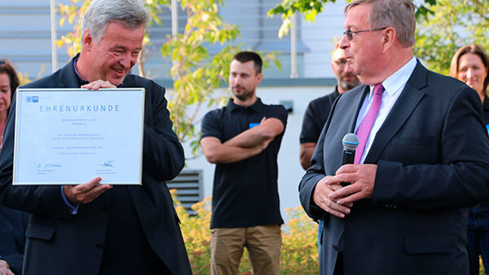 Burghard Loewe, Hauptgeschäftsführer der IHK Lahn-Dill (rechts) übergibt Jens Kuhn eine Ehrenurkunde.