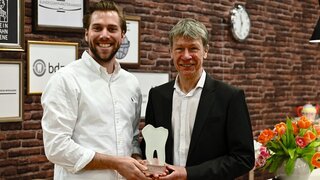 BdZA-Vorsitzender Maximilian Voß (links) überreicht Prof. Dietmar Oesterreich am IDS-Stand der Bundeszahnärztekammer den Alumni-Preis.