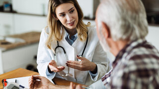 Hausärztin mit älterem Patienten