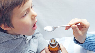 Kind nimmt Fiebersaft ein