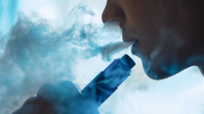 vaping man holding a mechanical mod. A cloud of vapor. vaping man holding a mod. A cloud of vapor.