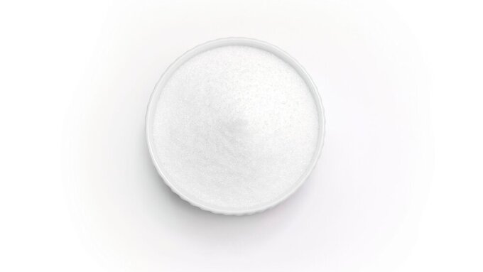 Isolated natural sweetener Erythritol, produced by fermentation from corn, called dextrose in ceramic bowl on white background. Sugar substitute. Horizontal plane, copy space for text,top view.