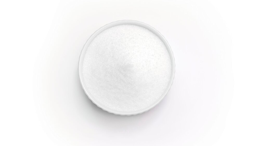 Isolated natural sweetener Erythritol, produced by fermentation from corn, called dextrose in ceramic bowl on white background. Sugar substitute. Horizontal plane, copy space for text,top view.